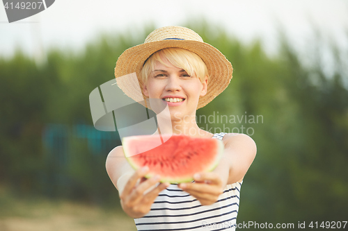 Image of Beautiful girl in straw hat eating fresh watermelon. Film camera style