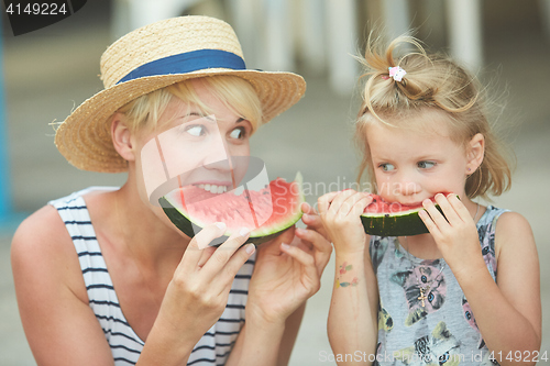 Image of Mother And Daughter Enjoying Slices Of WaterMelon