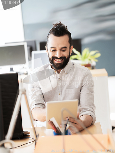 Image of happy creative male office worker with tablet pc