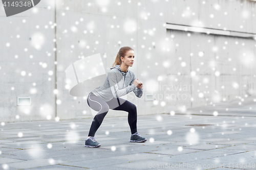 Image of woman doing squats and exercising outdoors