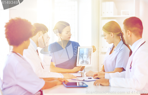 Image of group of doctors with x-ray on tablet pc at clinic