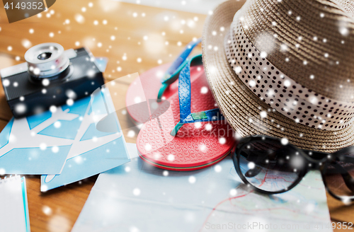 Image of close up of travel map, flip-flops, hat and camera