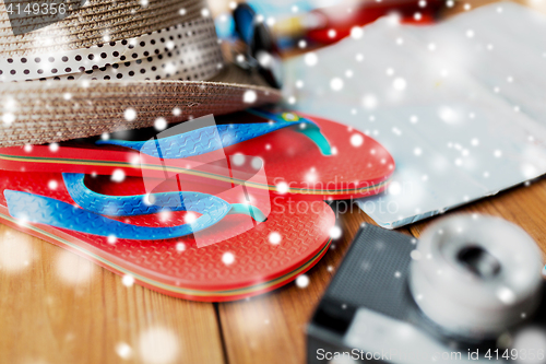 Image of close up of travel map, flip-flops, hat and camera