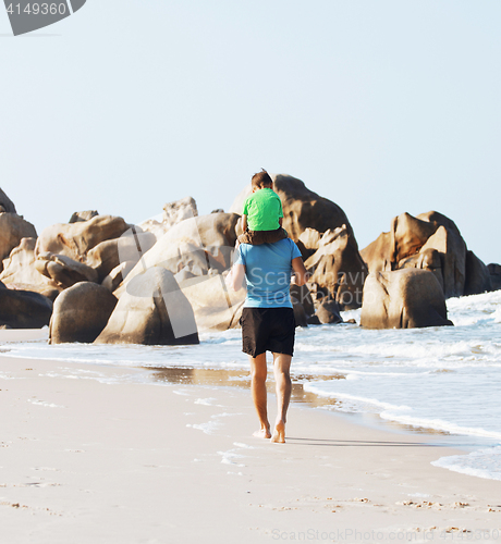 Image of happy family on beach playing, father with son walking sea coast