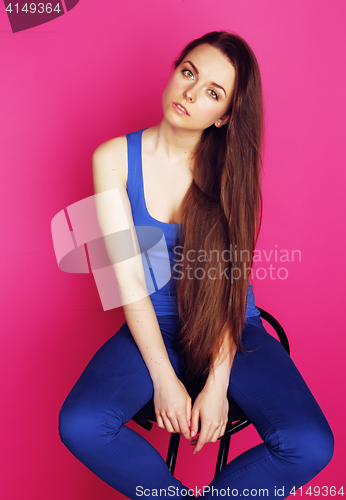 Image of young happy slim girl with skipping rope on pink background smil