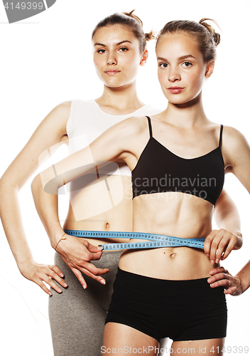 Image of two sport girls measuring themselves isolated on white