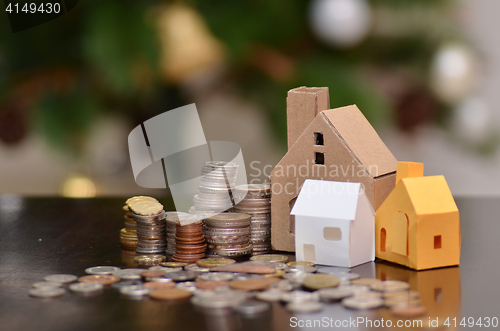 Image of Paper house and stacks of coins standing