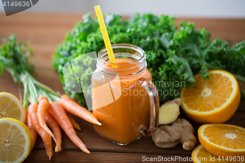 Image of glass jug of carrot juice, fruits and vegetables