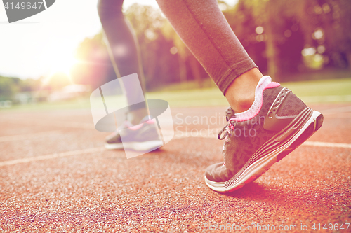 Image of close up of woman feet running on track from back