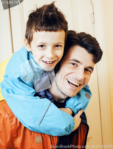 Image of young handsome father with his son fooling around at home, lifestyle people concept