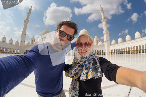 Image of Couple taking selfie in Sheikh Zayed Grand Mosque, Abu Dhabi, United Arab Emirates.