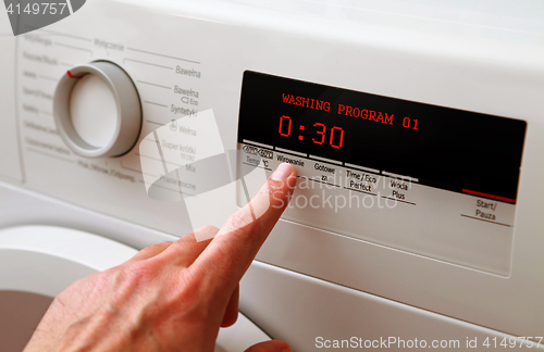 Image of man hand adjusting washing machine