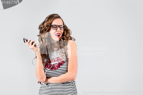 Image of Happy young woman listening music with headphones.