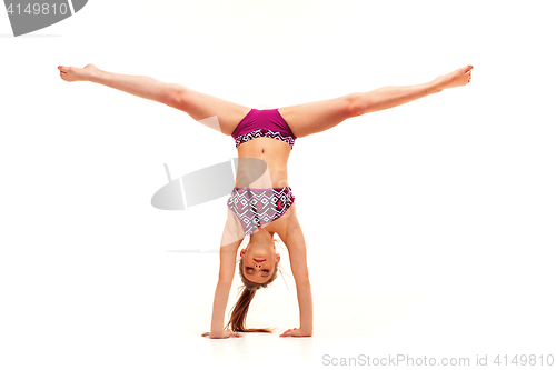 Image of The teenager girl doing gymnastics exercises isolated on white background