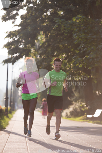 Image of young multiethnic couple jogging in the city