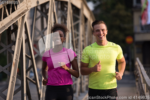 Image of multiethnic couple jogging in the city