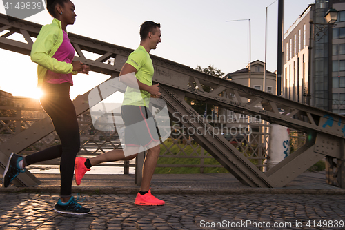 Image of young multiethnic couple jogging in the city