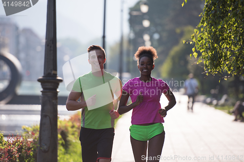 Image of young multiethnic couple jogging in the city