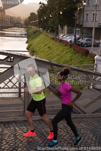 Image of young multiethnic couple jogging in the city