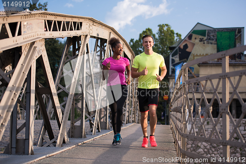 Image of multiethnic couple jogging in the city
