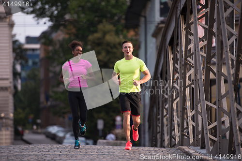 Image of multiethnic couple jogging in the city