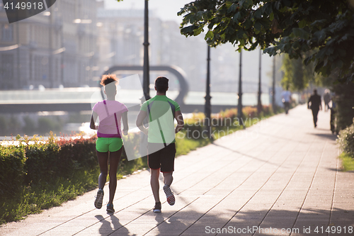 Image of young multiethnic couple jogging in the city