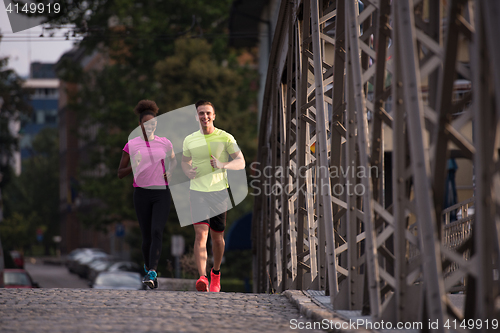 Image of multiethnic couple jogging in the city