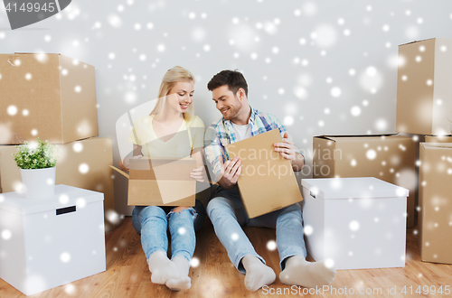 Image of smiling couple with many boxes moving to new home