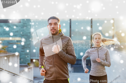 Image of happy couple of sportsmen running upstairs in city