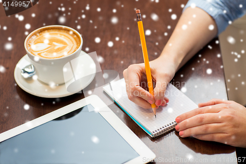 Image of close up of woman writing to notebook with pencil