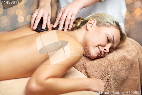 Image of close up of woman having hot stone massage in spa