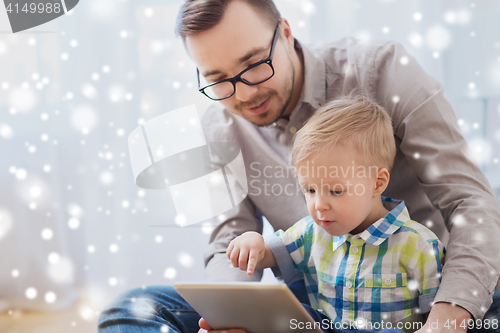 Image of father and son with tablet pc playing at home