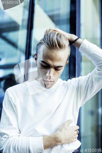 Image of young modern hipster guy at new building university blond fashion hairstyle having fun, lifestyle people concept