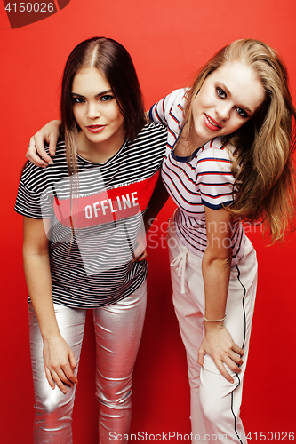 Image of two best friends teenage girls together having fun, posing emotional on red background, besties happy smiling, lifestyle people concept