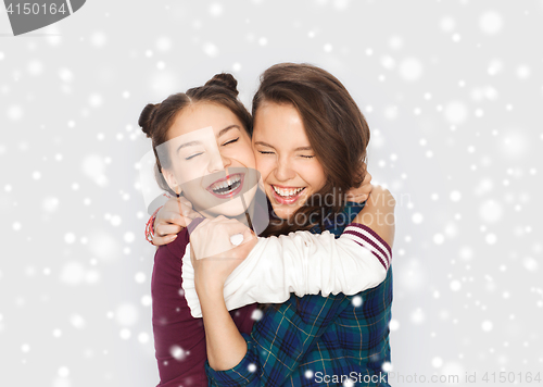 Image of happy smiling teenage girls hugging over snow