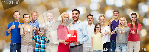 Image of happy people with sale sign showing thumbs up