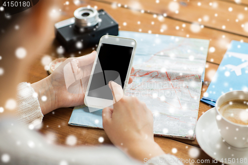 Image of close up of traveler hands with smartphone and map