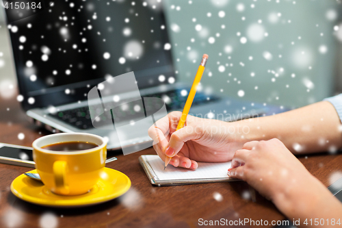 Image of close up of woman writing to notebook with pencil