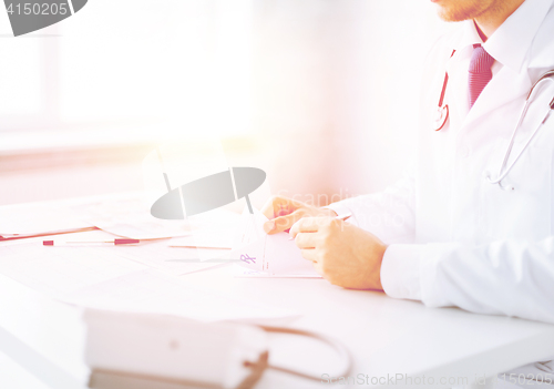 Image of male doctor writing prescription paper