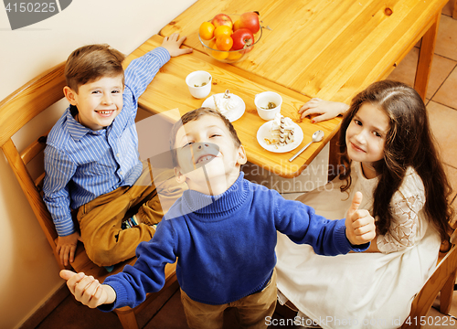 Image of little cute boys eating dessert on wooden kitchen. home interior. smiling adorable friendship together forever friends, lifestyle people concept