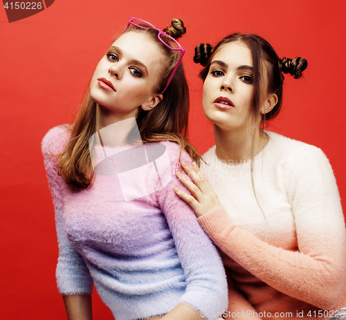 Image of two best friends teenage girls together having fun, posing emotional on red background, besties happy smiling, lifestyle people concept