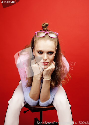 Image of young pretty emitonal posing teenage girl on bright red background, happy smiling lifestyle people concept