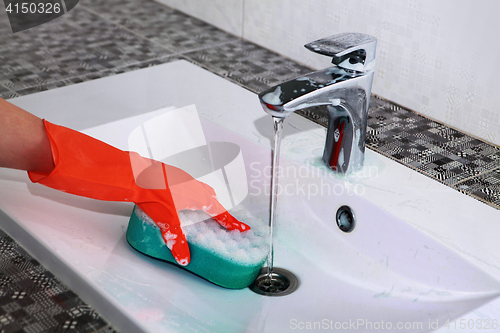 Image of hand of woman in glove washes sink