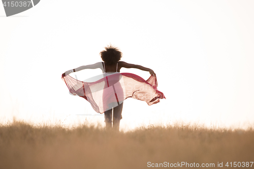 Image of black girl dances outdoors in a meadow