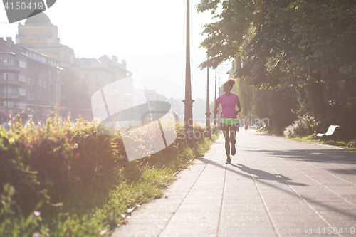 Image of african american woman jogging in the city