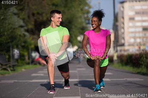 Image of jogging couple warming up and stretching in the city