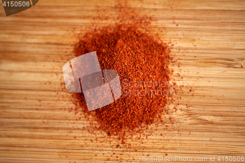 Image of cayenne pepper or paprika powder on wood