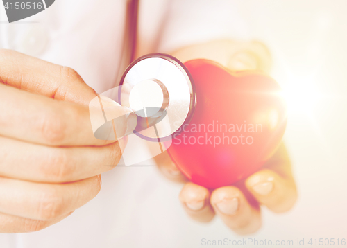 Image of male hands holding red heart and stethoscope