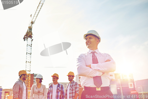 Image of happy builders and architect at construction site