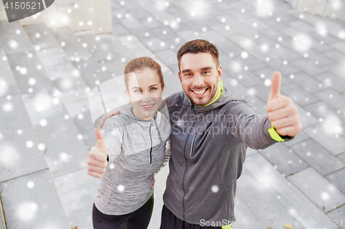 Image of couple of sportsmen showing thumbs up outdoors
